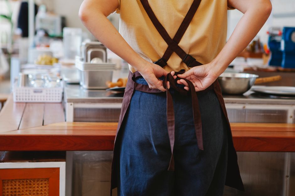 근무를 마치고 앞치마 끈을 푸는 사람